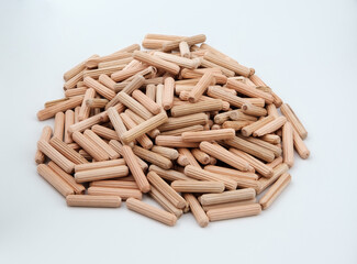 Pile of wooden furniture dowels isolated on gray.