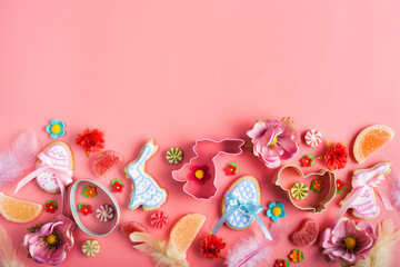 Easter cookies candies sugar sprinkles and cutters on pink background. Space for text