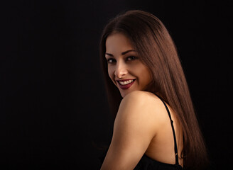 Beautiful makeup woman with long hair looking happy on black background. Closeup portrait