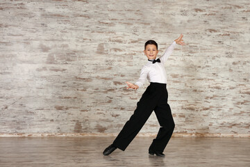 Adorable little boy dancing in studio, space for text
