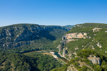Fototapeta na wymiar The towering green cliffs in the middle of the Gorges de lArdeche in Europe, France, Ardeche, in summer, on a sunny day.