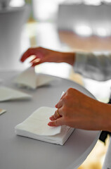 Female Waiters Hand Folding Paper Napkins In Restaurant