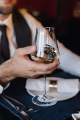 Glass with wine in the hand of the groom