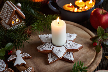 Christmas candlestick made of gingerbread, with apples, gingerbread cookies and floating candles