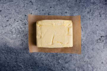 Butter cube on brown paper with a gray background