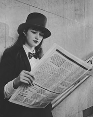 retro portrait of a young girl with a newspaper in her hands. woman standing in a tunnel underpass. black and white photo