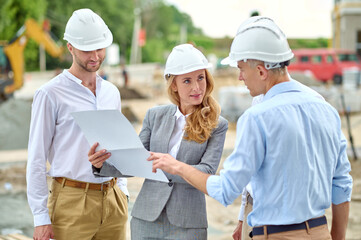 Woman with document looking questioningly at man