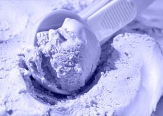 Close up of scoop with ice cream ball. Toning in the color of the year 2022, very peri. Trendy colors concept.