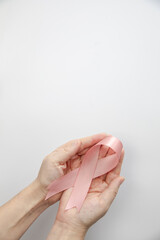 Woman holding pink ribbon on gray background, top view. Breast cancer awareness concept, Female health care concept copy space