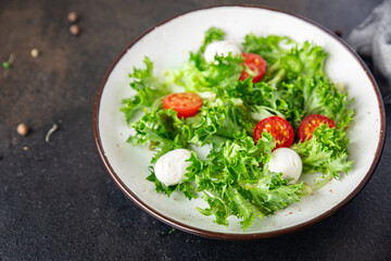 salad mozzarella, tomato, lettuce, arugula healthy meal food diet snack on the table copy space food background rustic. top view keto or paleo diet veggie vegan or vegetarian food