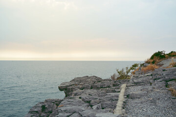 Sea view with sunlight gray rocks in sea with calm wales, colorful image.