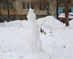 A snowman in the courtyard of a residential building