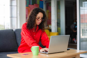 African American business freelance woman working at home with online communication using laptop