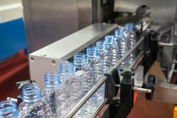 The empty PET bottles  on the conveyor belt for filling process in the drinking water factory.
