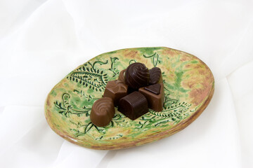 a lot of variety chocolate pralines on a clay plate