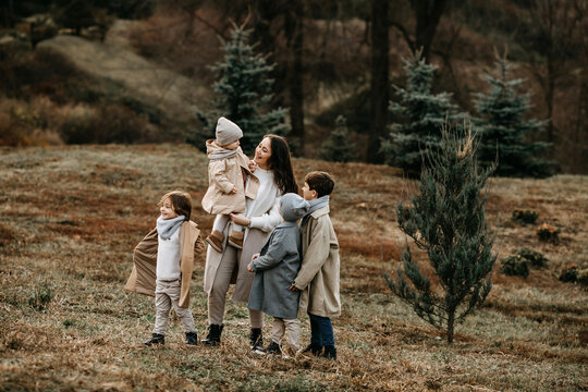 Mother With Many Children Walking In A Park, On An Autumn Day.