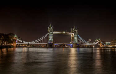 The iconic Tower Bridge in London, view to the illuminated Tower Bridge and skyline of London, UK, just after sunset.