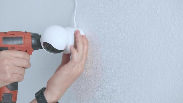 Man Hands Technician Worker Use Electric Drill And Install Cctv Camera On Wall For Security
