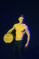 Viticulture concept. Attractive sexy man with wooden barrel of wine or beer. Handsome man winemaker...