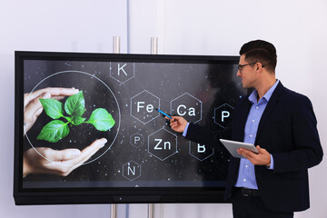 Teacher using interactive board in classroom during lesson