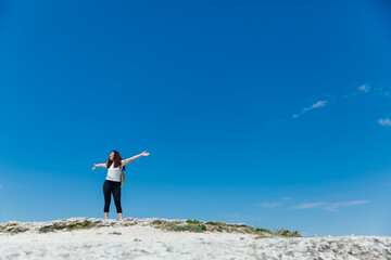 tourist woman traveler on top of a mountain alone looks at the landscape