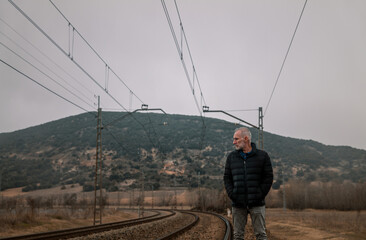Obraz premium Adult man in warm clothing with railway in countryside. Shot in Castilla la Mancha, Spain