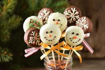 Homemade Christmas cake pops in white and milk chocolate in the form of snowmen, trees and snowflakes.