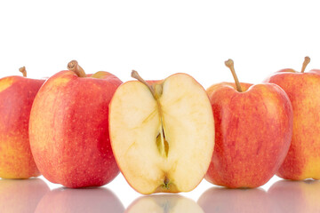 One half and several whole organic red apples, close-up, isolated on white.
