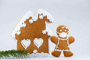 Romantic gingerbread house, woman with protective face mask and spruce twig, Christmas time