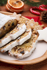 Traditional Christmas Stollen with icing sugar on wooden table, closeup