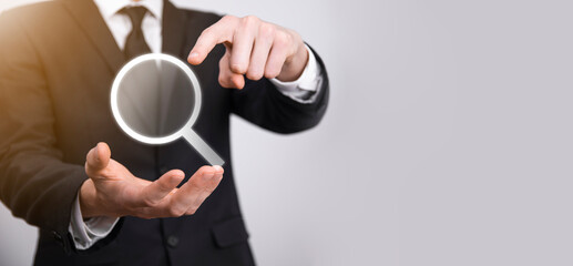 Male hand holding magnifying glass ,search icon on blue background. Concept search engine...