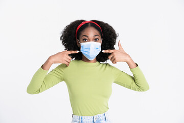 Young black woman pointing fingers at her face mask