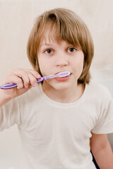 Portrait of young boy with toothbrush cleaning teeth in the morning