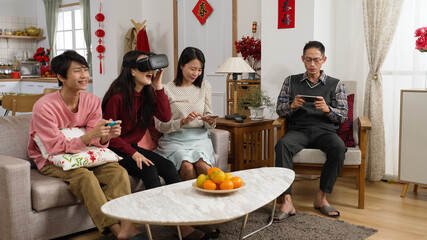 family addictive to electronics are playing with smartphones. vr glasses and video game in the...
