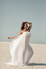 Fototapeta na wymiar Beautiful sensual mature woman in white pareo on sandy summer beach