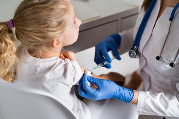 vaccination of children, a little girl at a doctor's appointment, an injection in the arm, the conce