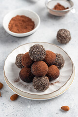 Raw energy balls with chia seeds, cocoa powder and almonds on gray background. vegan alternative food. vertical image. top view