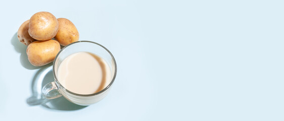 Potato milk. A cup with milk and potato tubers. Alternative plant milk