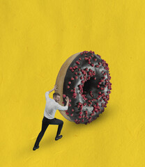 Contemporary art collage of man in classic cloth pushing big chocolate donut uphill isolated over yellow background