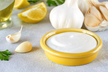 Fototapeta na wymiar Garlic sauce with ingredients. Traditional middle eastern sauce toum. Closeup