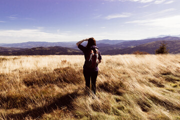 Girl with a backpack enjoys the autumn mood view of the mountains