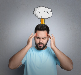 Young man having headache on light grey background. Illustration of atomic explosion representing severe pain