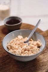 Homemade melted cheese curd served with baked milk and jam on wooden cutboard. Healthy breakfast. Haze effect. Selective focus