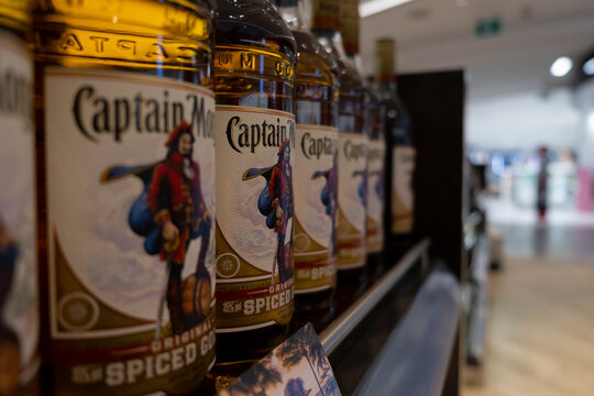 Row of Captain Morgan Spiced rum glass bottles on the shelf at a liquor store. Selective focus, blurred foreground and background.