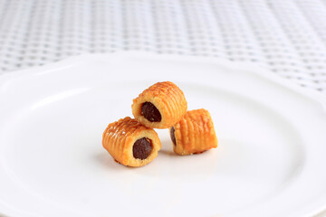 Fresh Baked Pineapple Tart Roll Cookies (Tart Nanas or Kuih Nenas or Nastar Gulung) on White Plate, Isolated