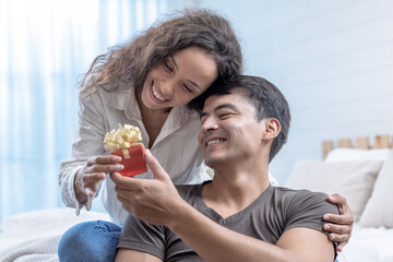 Happy young couple, Caucasian man gives his girlfriend a gift box on a special day, Wedding anniversary, Valentine's Day, Propose.