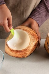 Female Hand Shredded  Young Coconut Flesh to the Bowl, Preparation Making Es Kelapa Muda (Young Coconut Ice) for Ramadan Breakfasting