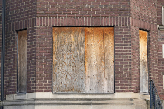old abandoned apartment building with boarded up windows