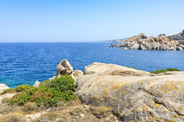Seascape with blue sea, blue sky and smooth rocks on the shore