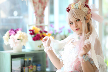 Beautiful young woman with white lolita dress with flowers garden Japanese fashion